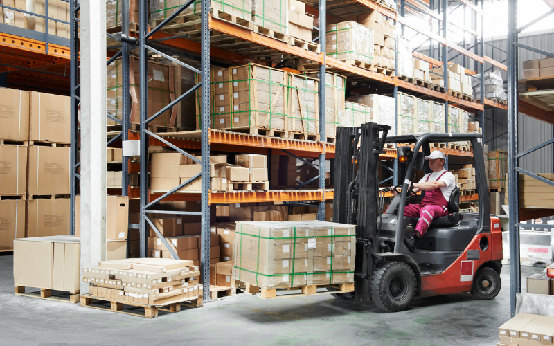 Tài xế lái xe nâng vận chuyển và sắp xếp hàng hóa trong kho